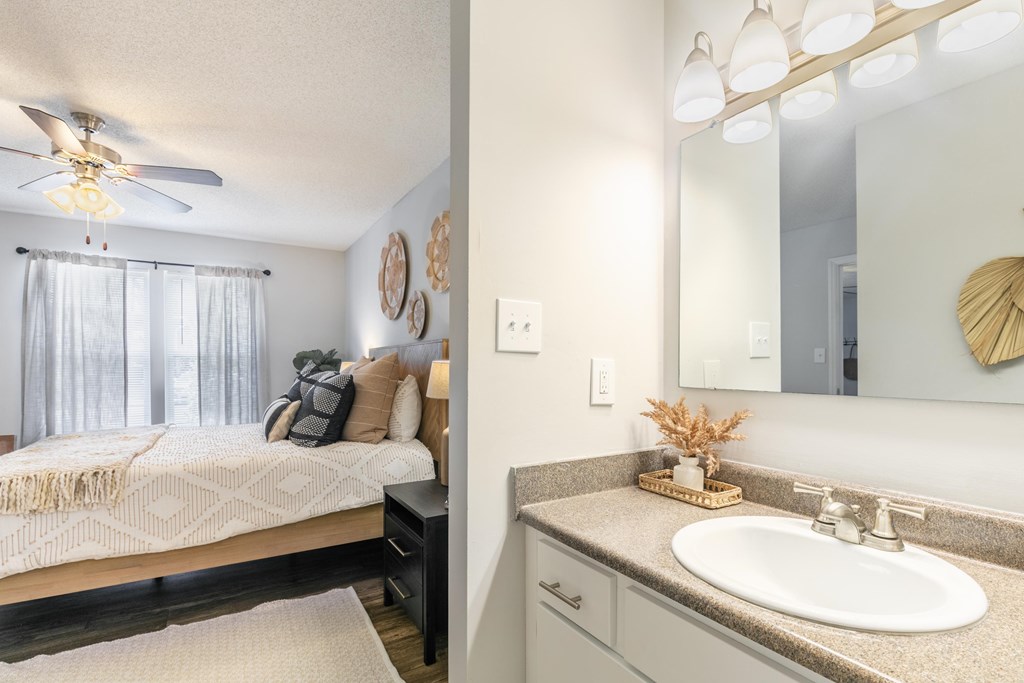 a bedroom with a bed and a bathroom with a sink